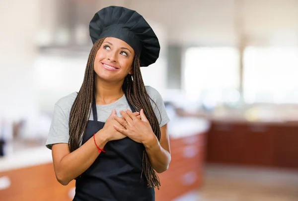 Portrait of a young black baker woman doing a romantic gesture, in love with someone or showing affection for some friend