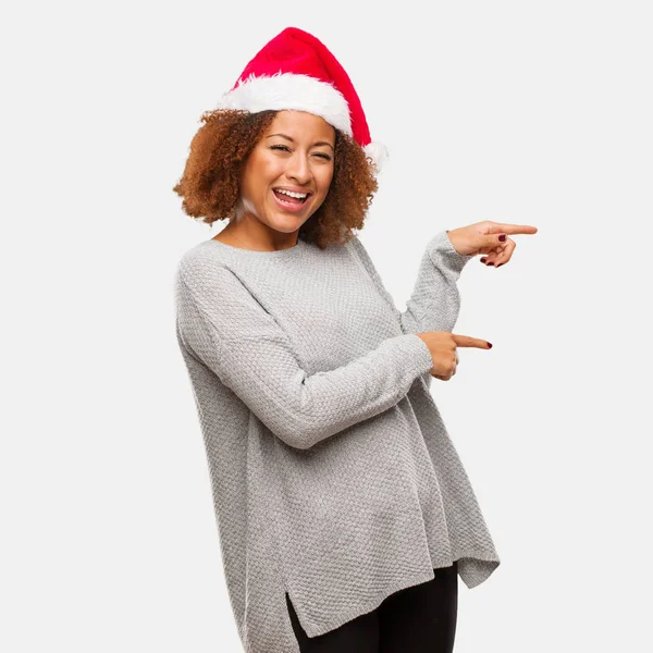 Joven Mujer Negra Con Sombrero Santa Señalando Lado Con Dedo —  Fotos de Stock