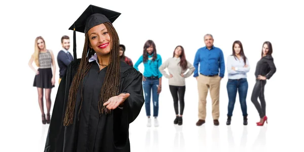 年轻毕业的黑人妇女戴辫子伸出手来问候某人或示意帮助 高兴和兴奋 — 图库照片