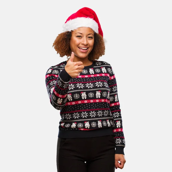 若いは トレンディなクリスマスのセーターを笑顔と調達親指の印刷での女性を黒します — ストック写真