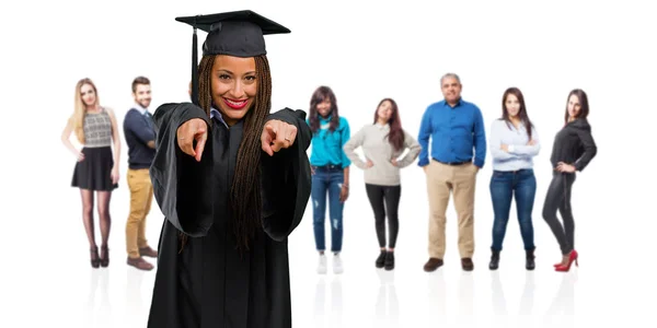 年轻毕业的黑人妇女穿着辫子开朗和微笑指向前面 — 图库照片