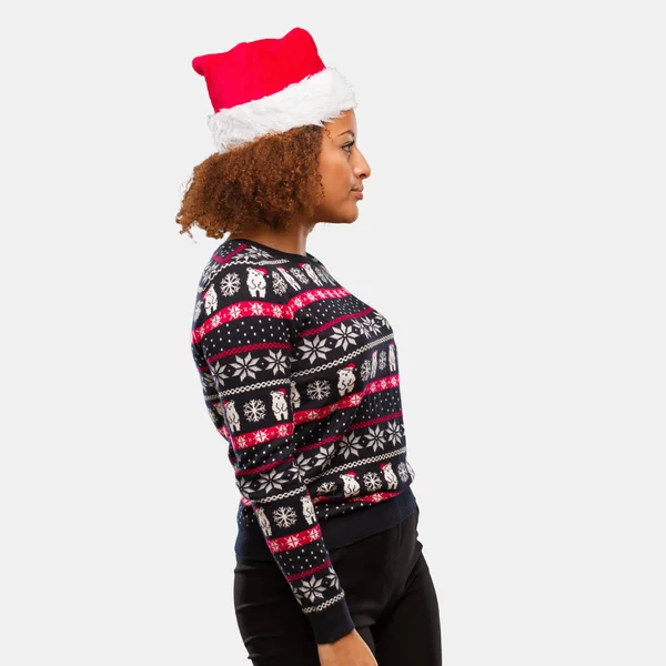年轻的黑人妇女在一个时髦的圣诞毛衣与打印在旁边看前面 — 图库照片