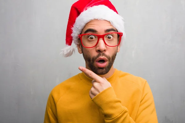 Jovem Celebrando Dia Natal Segurando Presentes Apontando Para Lado — Fotografia de Stock