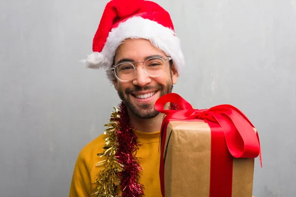 Młody Mężczyzna Siedzący Darami Obchodzi Boże Narodzenie Przejście Broni Uśmiechając — Zdjęcie stockowe