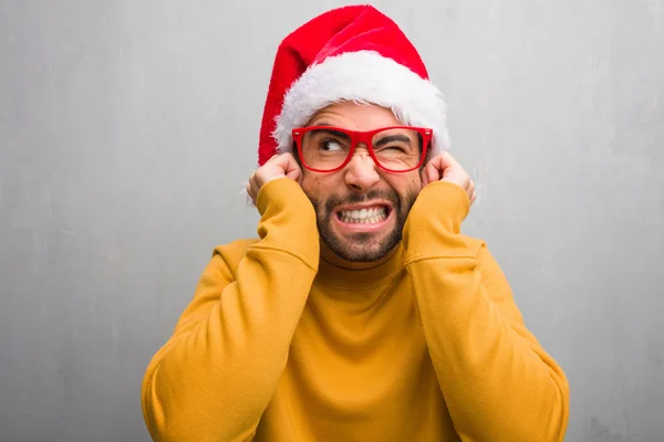 若い男の手で耳を覆って贈り物を持ってクリスマスの日を祝う — ストック写真