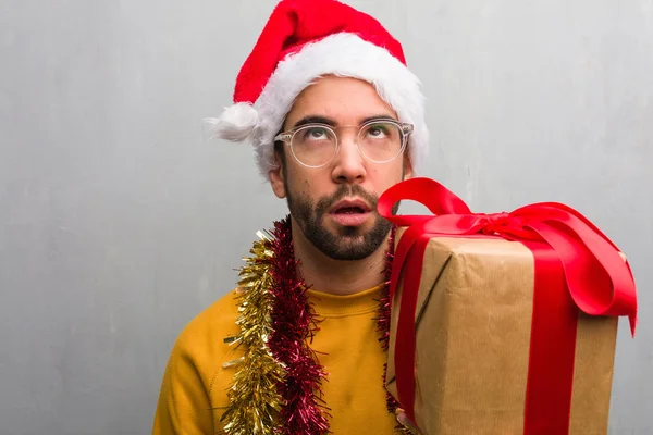 クリスマス疲れや退屈を祝う贈り物に座っている若い男 — ストック写真