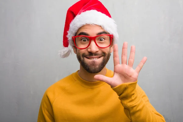 若い男は祝うクリスマス ギフト表示番号 を保持 — ストック写真