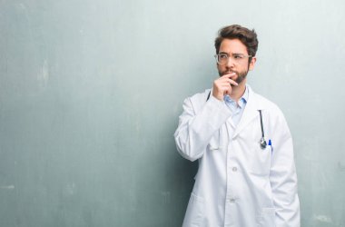 Genç dostu Doktor adama karşı bir grunge duvar bir kopya alanı şüphe ve karışık, düşünce ile bir fikir ya da bir şey hakkında endişeli