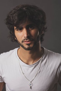 Genç yakışıklı adam neşeli ve kendine güvenen Studio kamera bakıyor 
