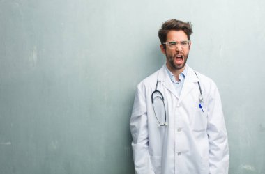 Öfkeli, negatif ve çılgın çığlık genç dostu Doktor adam çok kızgın ve üzgün, çok gergin bir kopya alanı ile bir grunge duvara