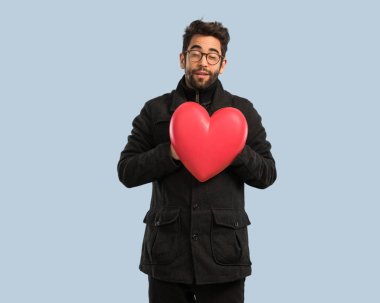 Genç adam bir kalp şekli tutan