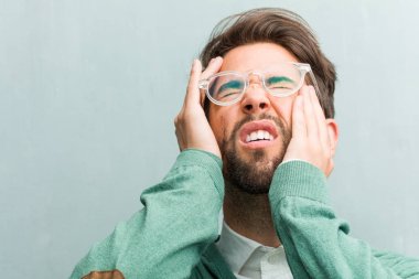 Genç yakışıklı girişimci adam yüz closeup sinirli ve umutsuz, kızgın ve üzgün başında elleriyle