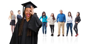 Genç örgüler neşeli ve heyecanlı ve çığlık, onay ve başarı kavramı ok jest yapıyor kendine güvenen giyen siyah kadın mezun oldu.