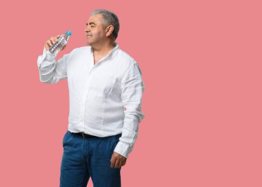 Memnun gülümsüyor, bir şişe soğuk su tutan, o nemlendirici vücut için önemli olduğunu hatırlayarak adam orta yaşlı