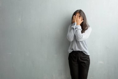 Endişeli ve korkmuş, seyir ve yüz, korku ve anksiyete kavramı kapsayan bir grunge duvara Genç Hintli kadın hisseder