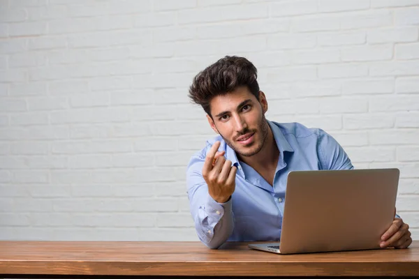 Ung Forretningsmann Som Sitter Jobber Med Bærbar Inviterer Til Komme – stockfoto