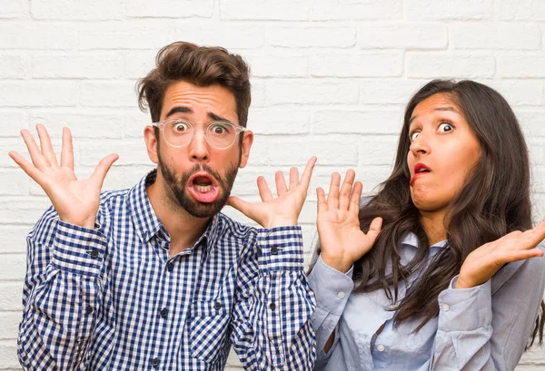 Young indian woman and caucasian man couple crazy and desperate, screaming out of control, funny lunatic expressing freedom and wild