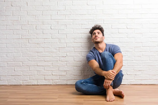Jovem Homem Natural Sentar Chão Madeira Olhando Para Cima Pensando — Fotografia de Stock