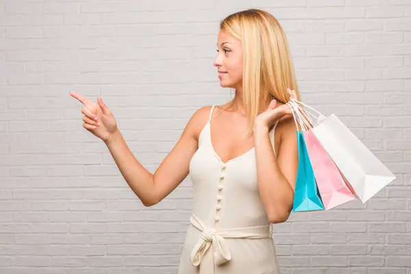 측면을 가리키는 여자의 초상화 자연스럽 캐주얼을 쇼핑백을 — 스톡 사진
