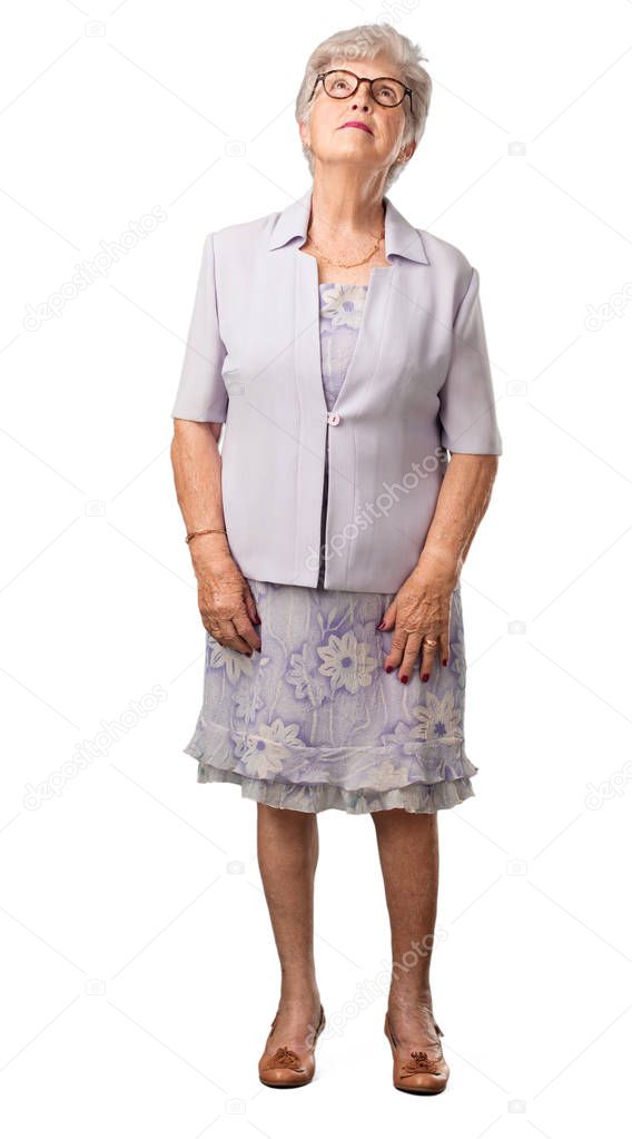 Full body senior woman looking up, thinking of something fun and having an idea, concept of imagination, happy and excited