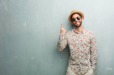 Gösterilen bir numaralı simgesi sayma, matematik, kendinden emin ve neşeli kavramı renkli bir gömlek giymiş genç seyahat adam