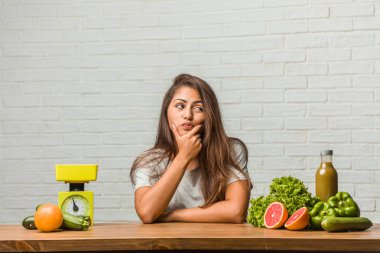 Diyet kavramı. Bir sağlıklı genç latin kadın şüphe ve karışık, düşünme, bir fikir ya da bir şey hakkında endişeli portresi
