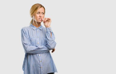 Isırma genç güzel sarışın kadın portresi çivi, gergin ve çok endişeli ve gelecek için korkmuş hissediyor panik ve stres