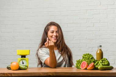 Diyet kavramı. Pozitif ve güler yüzlü gel, kendinden emin ve gülümseyen bir hareketi el ile yapmak için davet sağlıklı genç bir latin kadın portresi