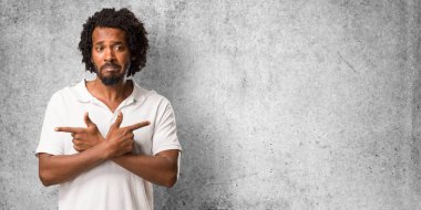 Yakışıklı Afro-Amerikan karışık ve şüpheli bir adam, kararsızlık kavramı iki seçenek arasında karar