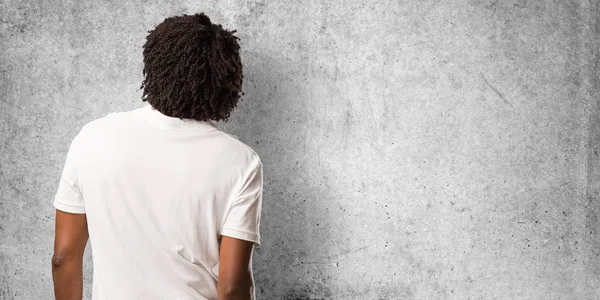 Handsome african american showing back, posing and waiting, looking back