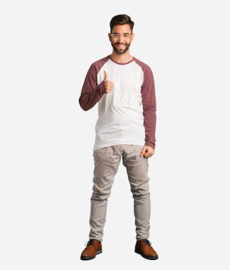 Gülümseyen ve başparmak kadar yükselterek genç yakışıklı adam