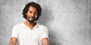 Yakışıklı Afro-Amerikan birisi selamlamak için uzanarak veya yardım, mutlu ve heyecanlı el hareketi