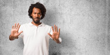 Yakışıklı Afrika kökenli Amerikalı ciddi ve kararlı, önde, el koyarak durdurmak jest, inkar kavramı