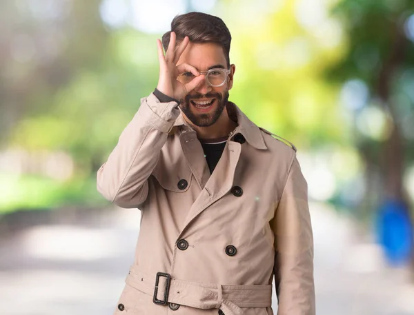 Joven Vistiendo Abrigo Trinchera Confiado Haciendo Buen Gesto Ojo — Foto de Stock