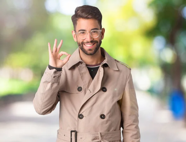 Young Man Wearing Trench Coat Cheerful Confident Doing Gesture — Stock Photo, Image