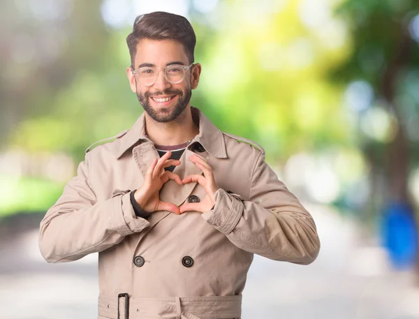 穿着风衣的年轻人用手做心脏形状 — 图库照片