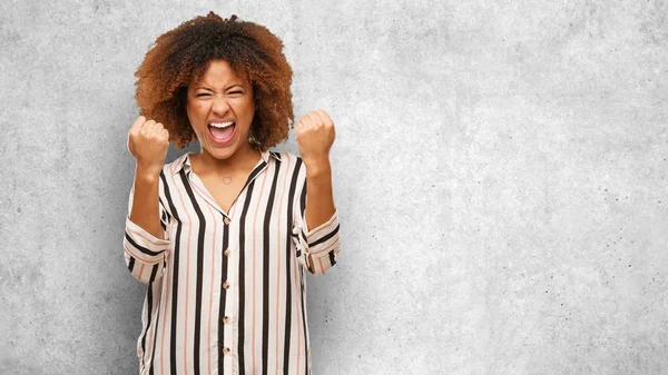 Young black afro woman surprised and shocked