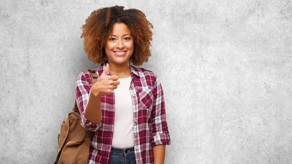 Young traveler black woman smiling and raising thumb up