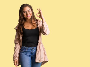 Tam vücut genç düzgün vücutlu kadın neşeli ve kendine güvenen ok jest yapıyor