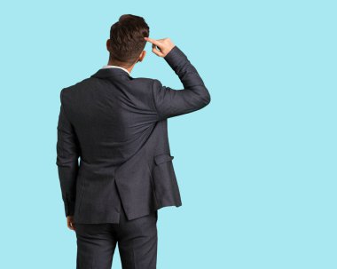 Genç yakışıklı iş adamı arkasından bir şey hakkında düşünme