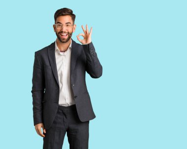 Genç yakışıklı iş adamı neşeli ve kendine güvenen ok jest yapıyor