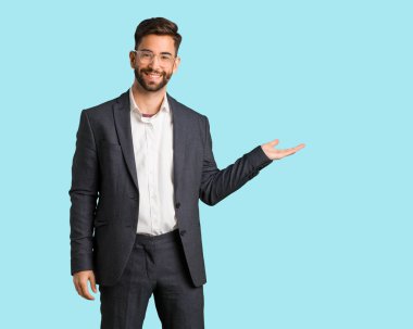 El ile bir şey tutan genç yakışıklı iş adamı