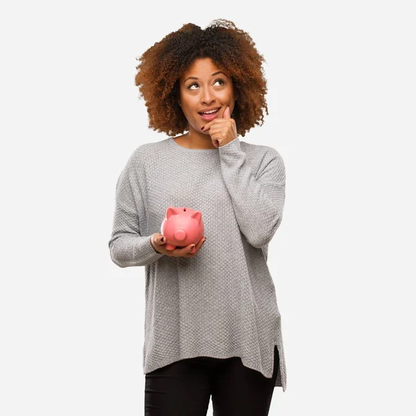 Junge Schwarze Frau Mit Sparschwein Zweifelnd Und Verwirrt — Stockfoto