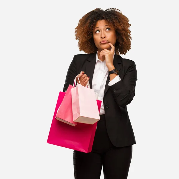 Young Black Woman Holding Shopping Bags Thinking Idea — Stock Photo, Image