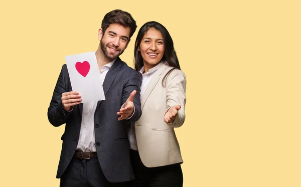 Young couple in valentines day reaching out to greet someone