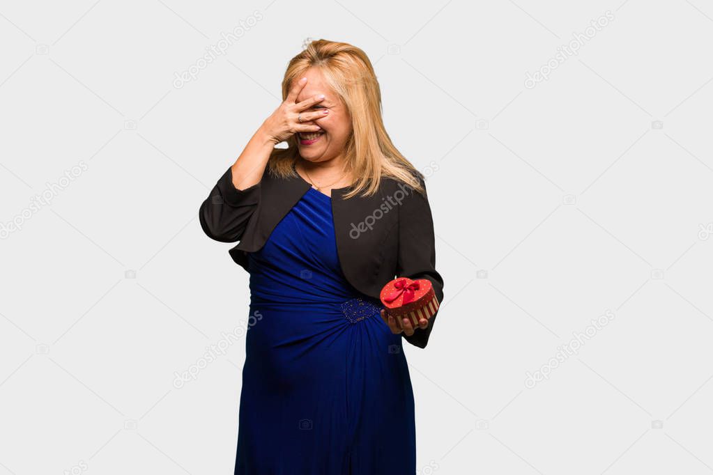 Middle aged latin woman celebrating valentines day embarrassed and laughing at the same time