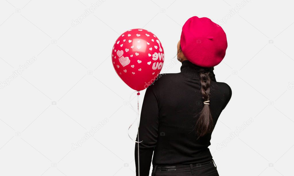 Young woman in valentines day from behind thinking about something