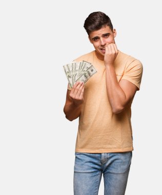 Çivi, sinirli ve tedirgin ısırma holding dolar genç adam