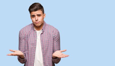 Genç serin şüphe ve omuzlarında shrugging adam