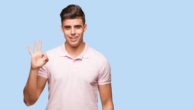 Genç yakışıklı adam neşeli ve kendine güvenen ok jest yapıyor